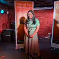 Pedestrian CEO Hema Badger-Mistry stands on a stage behind a microphone